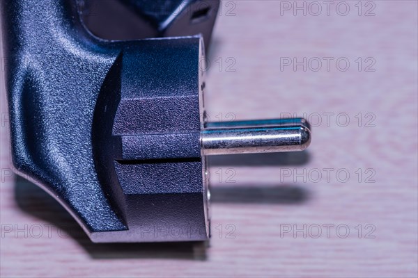 Closeup of computer power cord plug that plugs into electrical socket