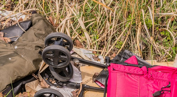 Various abandoned items, including a baby stroller, scattered in the grass, in South Korea