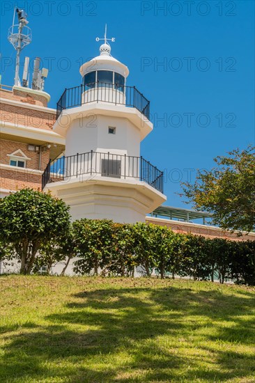 A close view of a white lighthouse with a balcony, set against a blue sky, in Ulsan, South Korea, Asia