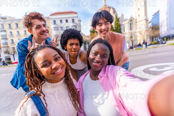 Happy young multi-ethnic friends taking a selfie in the city in a sunny day
