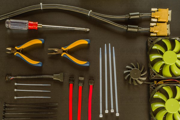 Flat lay of various computer tools and parts on black background