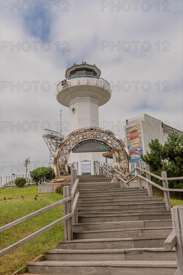 Entrance archway with a lighthouse in the background on an overcast day, in Ulsan, South Korea, Asia