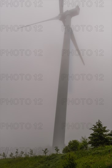 Large electric wind turbine in countryside hidden by heavy morning fog in Gangneung, South Korea, Asia