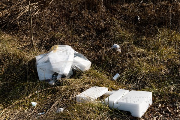Discarded polystyrene containers scattered in a field showcasing environmental neglect, in South Korea