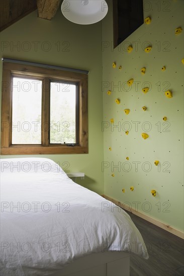 Child's bedroom with climbing wall on upstairs floor inside contemporary style log home, Quebec, Canada, North America