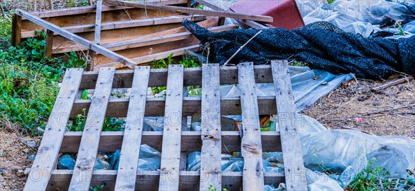 A chaotic pile of garbage with wood, plastic, and various debris, in South Korea