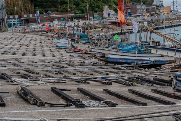 Array of ropes and mooring lines in a busy fishing boat dry dock on a grey day, in Ulsan, South Korea, Asia