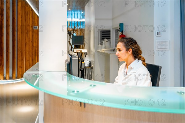 Side view photo with copy space of a female healthcare worker in the reception of an ophthalmology clinic