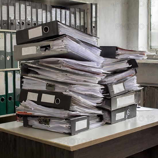 A chaotic-looking pile of files and documents on an office table, symbolising bureaucracy, AI generated, AI generated
