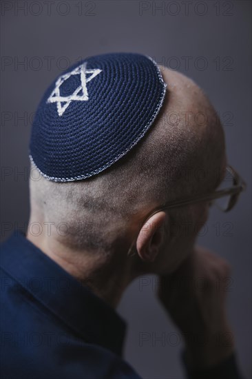 Jewish man wearing a kippa with a Star of David on his head, back view, studio shot, Germany, Europe