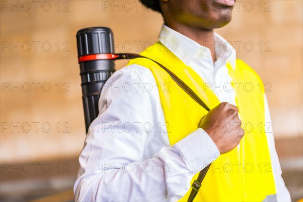 Close-up of an unrecognizable african architect carrying a drawings tub outdoors