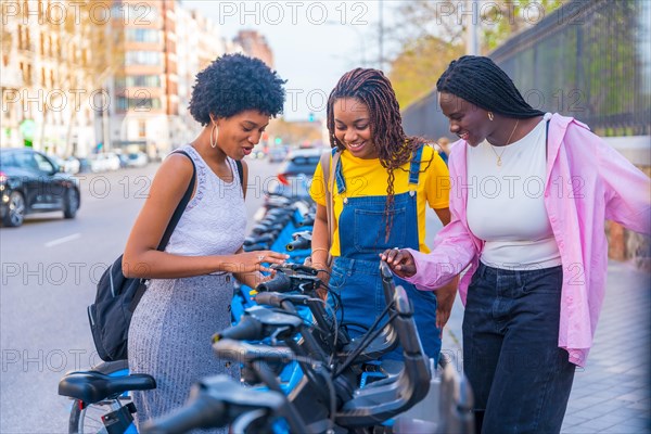 Multiracial female friends using phone in the public bike system