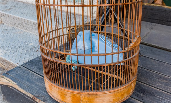 Old style rotary phone sitting in birdcage sitting outside on wooden step in Seoul, South Korea, Asia