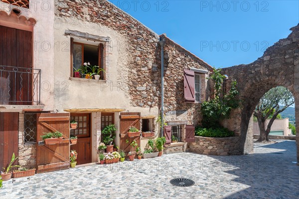 House facade and remains of the former town wall in the historic old town, Grimaud-Village, Var, Provence-Alpes-Cote d'Azur, France, Europe