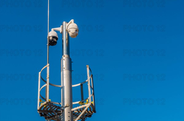 Closed circuit television devices and weather veins on metal pole against blue sky in Daejeon, South Korea, Asia