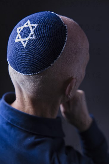 Jewish man wearing a kippa with a Star of David on his head, back view, studio shot, Germany, Europe