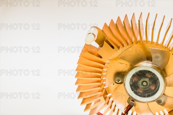 Closeup of round copper heat sink and plastic fan assembly on white background