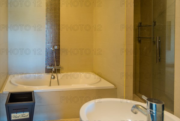 Modern bathroom with a clean bathtub, wall tiles, and a towel, in Chiang Mai, Thailand, Asia