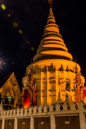 Illuminated temple with golden lights stands out against the dark night, in Chiang Mai, Thailand, Asia