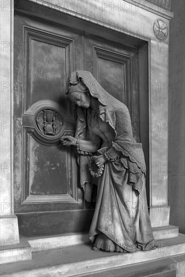 Sculpture of an old woman at a door with an hourglass, Monumental Cemetery, Cimitero monumentale di Staglieno), Genoa, Italy, Europe
