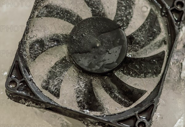 Closeup of computer case fan frozen in block of ice. Concept keep your computer cool