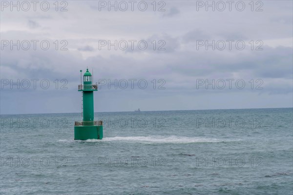 A solitary green buoy floats on the ocean waves under a cloudy sky, in Ulsan, South Korea, Asia