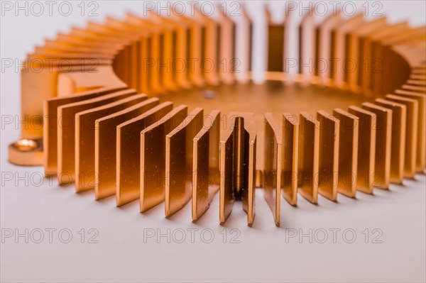 Closeup of round copper computer heat sink fins on white background