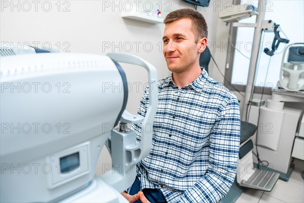 Man about to scan her eye in scanner machine in a clinic
