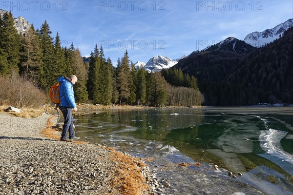 Hikers in winter on an icy lake, Lake Antholz in the Antholz Valley, Val Pusteria, South Tyrol, Italy, Europe