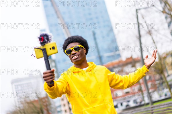 African cool and young streamer recording on online video using mobile in the city