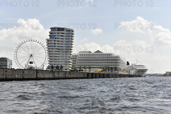 View of an urban skyline with a Ferris wheel and a cruise ship moored on the shore, Hamburg, Hanseatic City of Hamburg, Germany, Europe