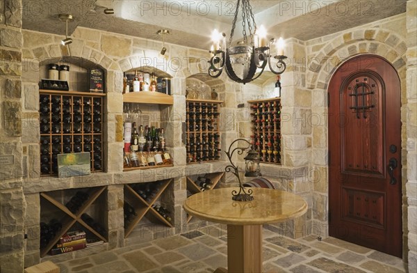 Medieval style beige and tan cut stone wine cellar in basement inside elegant style home, Quebec, Canada, North America