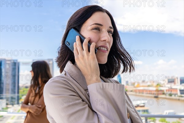 A woman is engaged in a conversation on her mobile phone