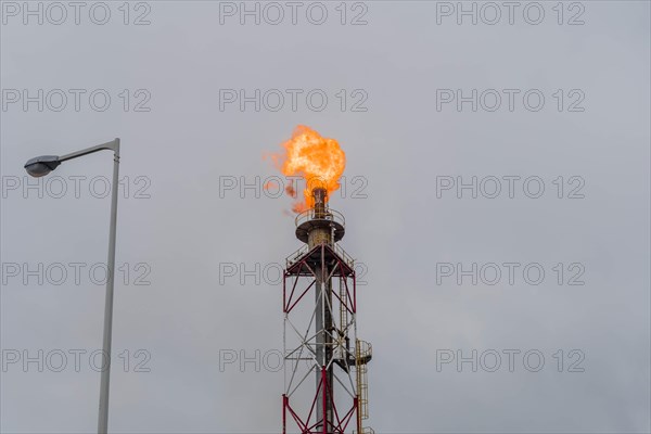 Flaring gas burns at the top of an industrial stack against a gloomy sky, in Ulsan, South Korea, Asia