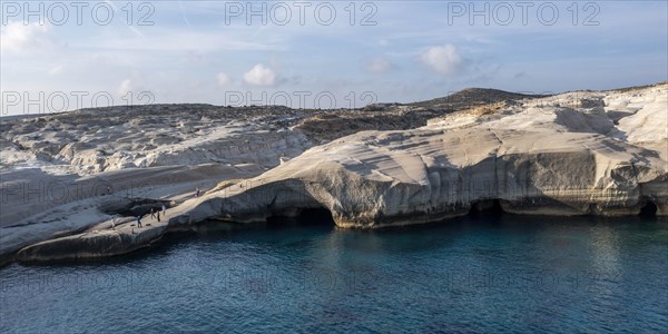 Tourists on the white rocks on the coast near Sarakinikoer, Milos, Cyclades, Greece, Europe
