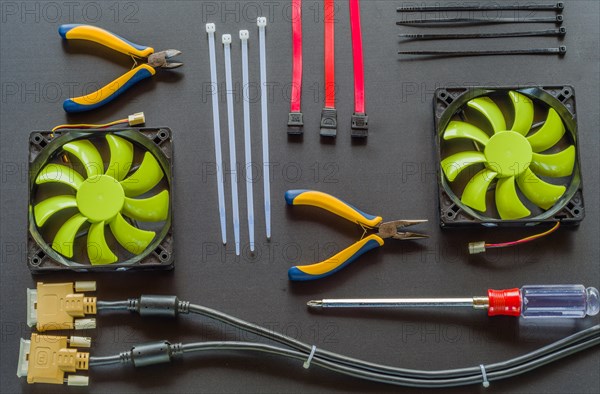 Flat lay of various computer tools and parts on black background