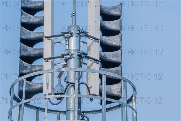 Bank of loud speakers and cctv camera with light blue sky in background in South Korea