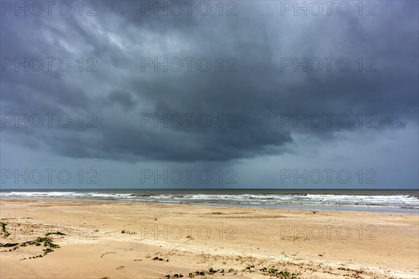 Dark rain clouds over the sea at Sargi beach in Serra Grande on the coast of Bahia, Bahia, Brazil, South America