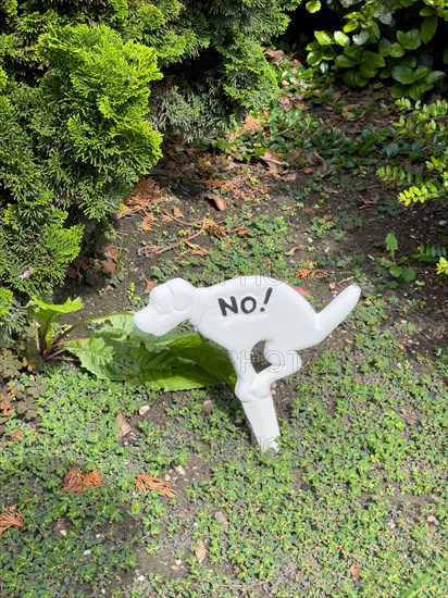 Sign in front garden in the form of a dog pooping dog pooing dog pooing dog pooing dog pooing dog pooing dog poo, North Rhine-Westphalia, Germany, Europe
