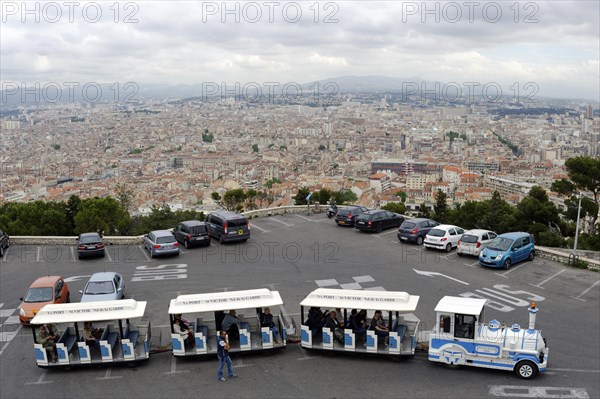 Marseille, A viewpoint with parked cars and tourist trains overlooks a large city, Marseille, Departement Bouches-du-Rhone, Provence-Alpes-Cote d'Azur region, France, Europe