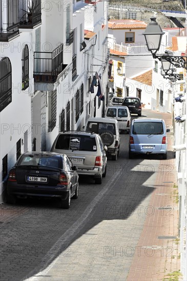 Solabrena, Narrow urban street with parked cars and traditional white houses, Costa del Sol, Andalusia, Spain, Europe