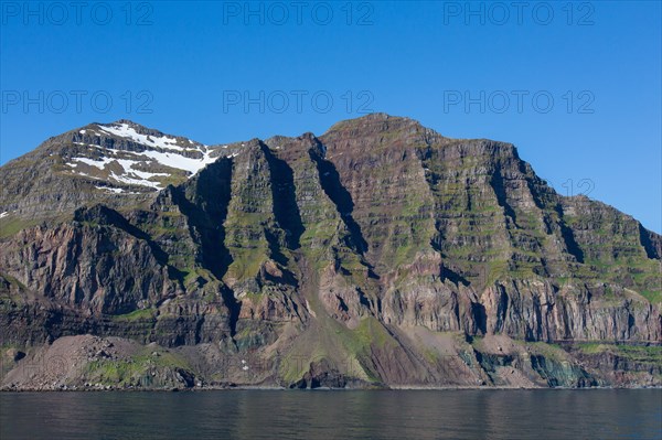 Rugged mountains and steep sea cliffs along the fjord Seyoisfjoerour, Seydisfjoerdur in summer, Eastern Region, Austurland, Iceland, Europe