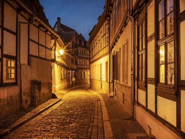 Narrow alley with half-timbered houses and cobblestones in the historic old town at dusk, UNESCO World Heritage Site, Quedlinburg, Saxony-Anhalt, Germany, Europe