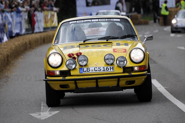 A classic yellow Porsche 911 on a rally track, flanked by spectators, SOLITUDE REVIVAL 2011, Stuttgart, Baden-Wuerttemberg, Germany, Europe