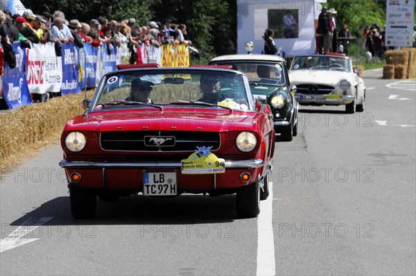 Red muscle car leads a line-up of classic cars in a rally, SOLITUDE REVIVAL 2011, Stuttgart, Baden-Wuerttemberg, Germany, Europe