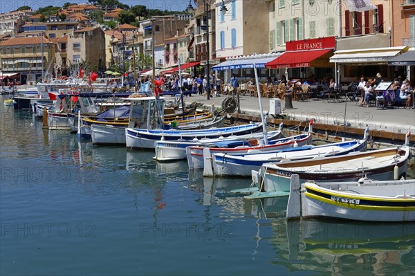 Cassis, the harbour, people strolling along a promenade with boats and pastel-coloured houses, Marseille, Departement Bouches-du-Rhone, Region Provence-Alpes-Cote d'Azur, France, Europe