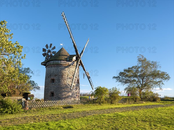 Old windmill behind a fence, casting long shadows in the evening sun, tower windmill, Endorf, Saxony-Anhalt, Germany, Europe