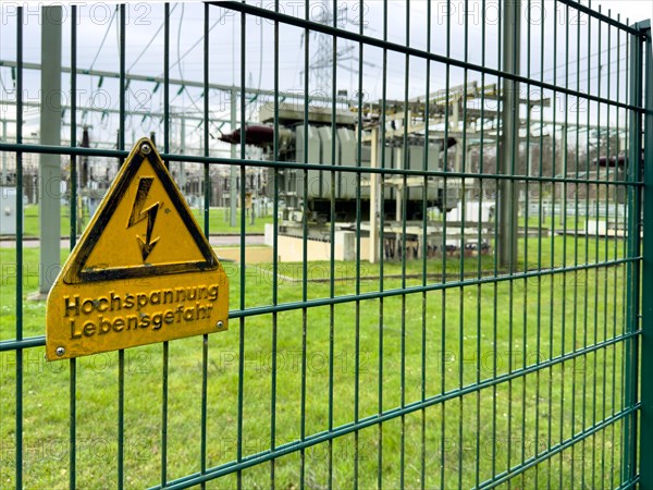 Warning sign Warning high voltage Danger to life on fence of substation Transformer station Part of electrical supply network with transformer Generator in the background High-voltage lines High-voltage pylon for secured power supply Power supply, Germany, Europe