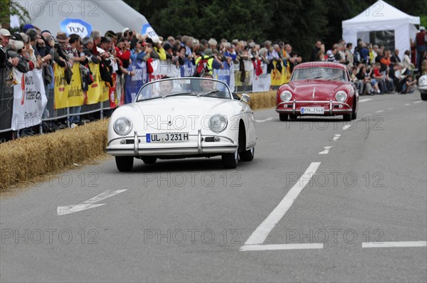 A white vintage convertible drives along a road race, straw bales on the sidelines, SOLITUDE REVIVAL 2011, Stuttgart, Baden-Wuerttemberg, Germany, Europe