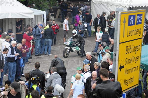 A motorcyclist rides through a crowd at a street racing event, SOLITUDE REVIVAL 2011, Stuttgart, Baden-Wuerttemberg, Germany, Europe